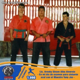 Lic. Arnoby Sinam Alba durante su examen de ascenso a cinturón azul en 1990, acompañado por el maestro Tony Jas y compañeros de entrenamiento. Fotografía histórica de Arnoby Sinam Alba durante el examen de ascenso a cinturón azul junto al maestro Tony Jas y otros practicantes de artes marciales en 1990.