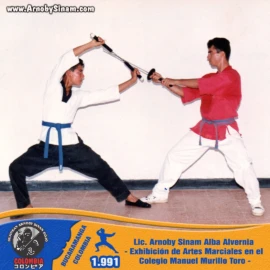 Lic. Arnoby Sinam Alba participando en una demostración técnica con espada japonesa durante una exhibición de artes marciales realizada en el Colegio Manuel Murillo Toro en 1991. Fotografía histórica de Arnoby Sinam Alba realizando una demostración de combate con espada japonesa durante una exhibición de artes marciales en el Colegio Manuel Murillo Toro en 1991.