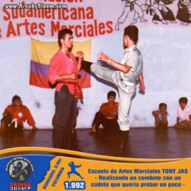 Arnoby Sinam participando en un combate de exhibición contra un cadete invitado durante una presentación marcial realizada en la Escuela de Artes Marciales Tony Jas en 1992. Arnoby Sinam enfrentando a un cadete en un combate de exhibición durante una demostración de artes marciales en la Escuela Tony Jas en Bucaramanga en 1992.
