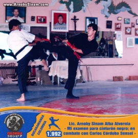 Momento histórico del examen para cinturón negro de Arnoby Sinam, enfrentándose en combate a Carlos Córdoba Sensei como parte de la evaluación técnica. Arnoby Sinam realiza un combate durante su examen para cinturón negro frente a Carlos Córdoba Sensei en 1992.