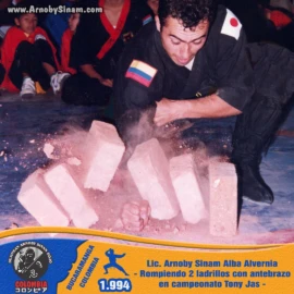 Fotografía histórica de Arnoby Sinam Alba realizando una demostración de rompimiento de ladrillos con el antebrazo durante el Campeonato Tony Jas en Bogotá en 1994. Arnoby Sinam Alba realizando una demostración de rompimiento de ladrillos con el antebrazo durante el Campeonato Tony Jas en Bogotá, Colombia, en 1994.