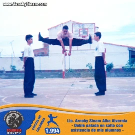 Fotografía histórica de Arnoby Sinam Alba realizando una doble patada en salto con la asistencia de sus alumnos durante un entrenamiento y demostración de artes marciales en Cúcuta en 1994. Arnoby Sinam Alba ejecutando una doble patada en salto asistida por sus alumnos durante una demostración de artes marciales en Cúcuta, Norte de Santander, en 1994.