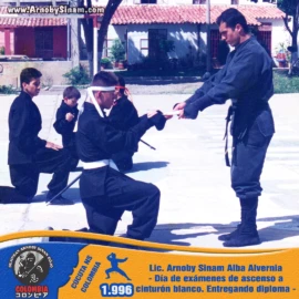 Ceremonia de entrega de diploma durante los exámenes de ascenso a cinturón blanco realizados por el Lic. Arnoby Sinam Alba en 1996. Lic. Arnoby Sinam Alba entregando un diploma durante exámenes de ascenso a cinturón blanco en Bujinkan Colombia en 1996.