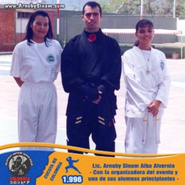 El Lic. Arnoby Sinam Alba comparte con la organizadora del evento y una de sus alumnas principiantes durante una jornada de integración y competencia de artes marciales en Cúcuta, Colombia. Lic. Arnoby Sinam Alba junto a la organizadora de un campeonato de artes marciales y una alumna principiante durante un evento realizado en Cúcuta, Colombia, en 1996.