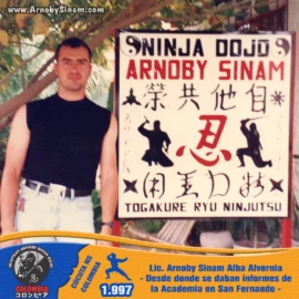 Fotografía histórica del Lic. Arnoby Sinam Alba junto al primer letrero informativo del Ninja Dojo Arnoby Sinam, utilizado para promover y orientar a los interesados en las clases de Ninjutsu en San Fernando. Lic. Arnoby Sinam Alba junto al letrero original del Ninja Dojo Arnoby Sinam en San Fernando, lugar desde donde se brindaba información sobre la academia y las clases de Ninjutsu en 1997.